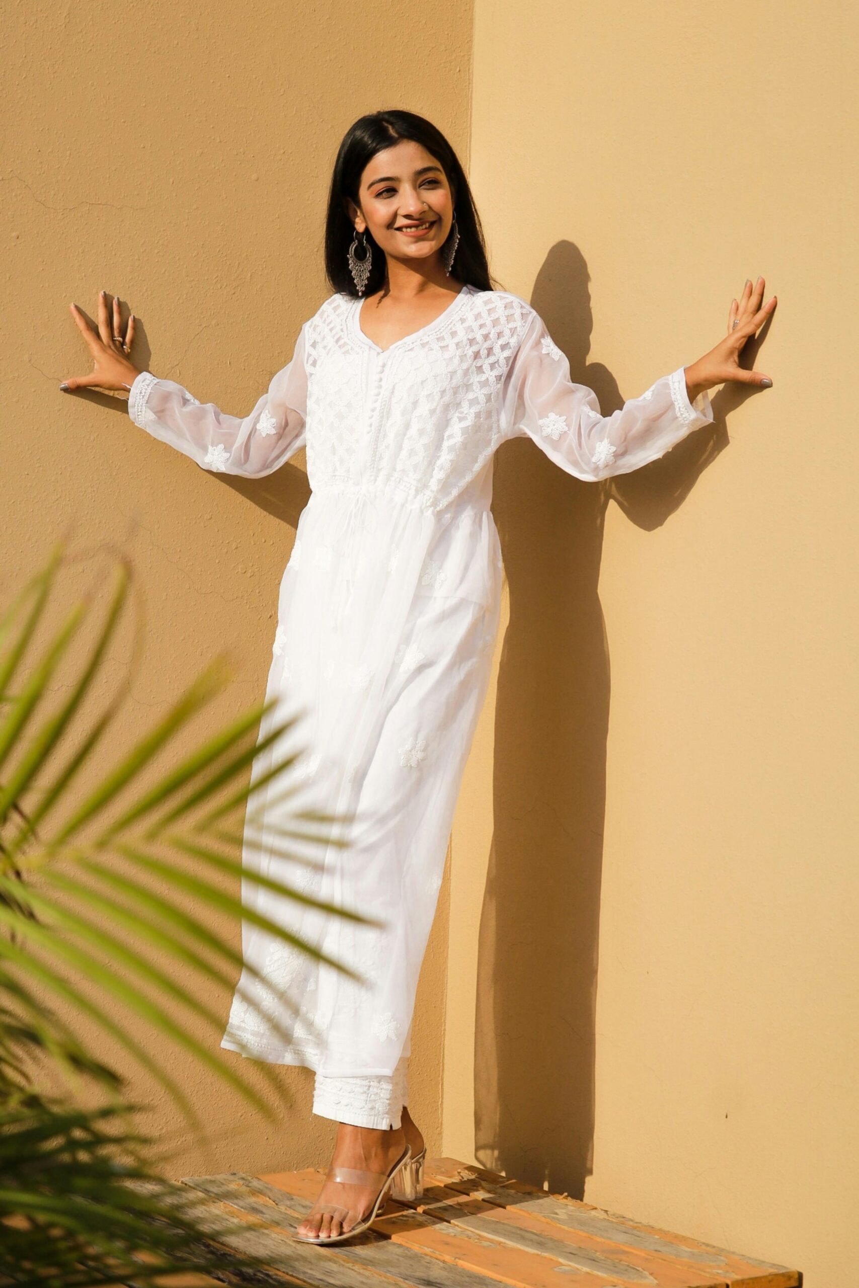Stylish woman in a white chikankari kurti outdoors, showcasing ethnic elegance.